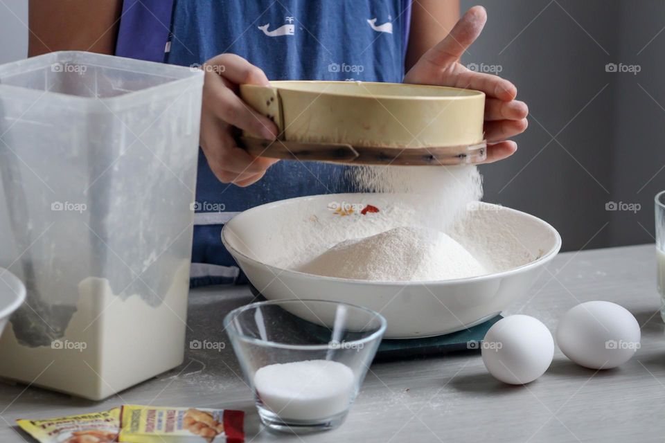 Child is sifting flour