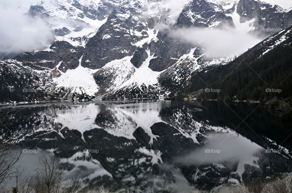 Snowy mountain reflecting on lake