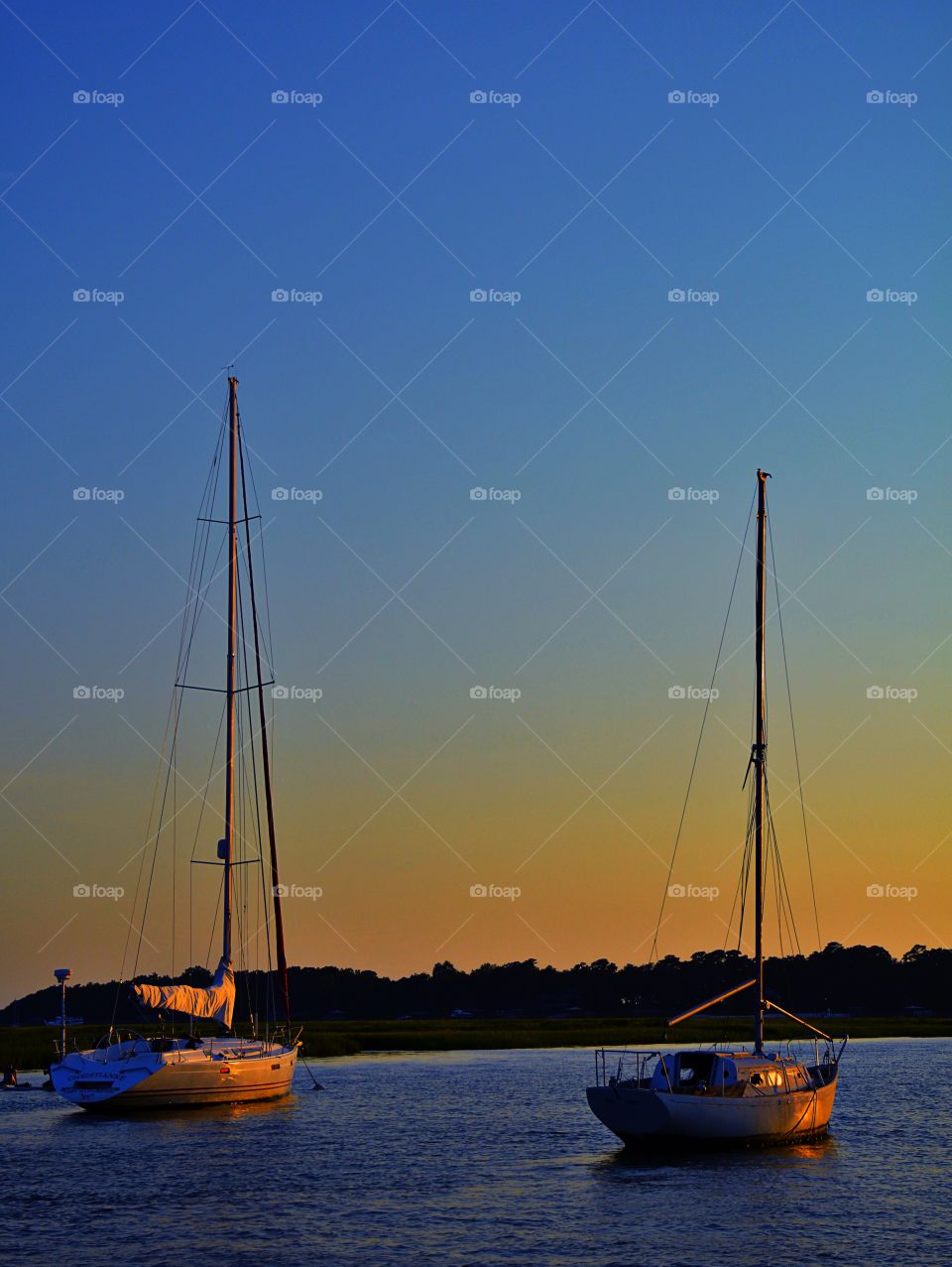 Sailboats in sea during sunset