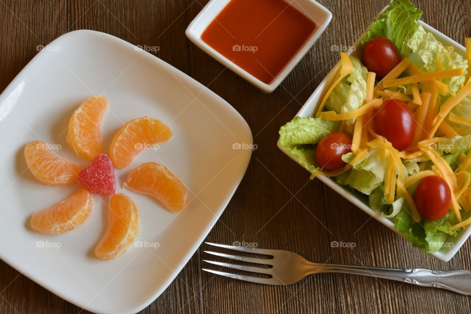Crisp salad with cheese and a plate of mandarin oranges