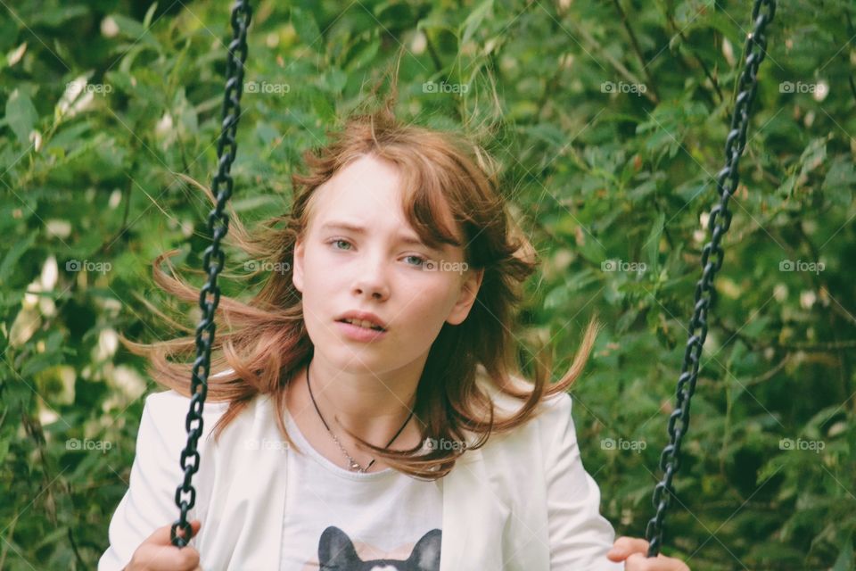 Girl swinging dressed in stylish clothes