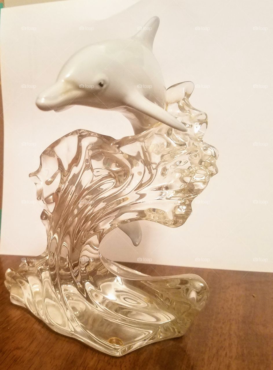 Porceilan dolphin on crystal wave