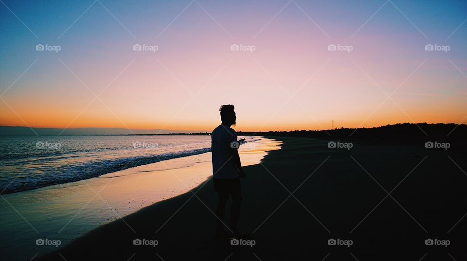 A man catches a glimpse of the sunrise.