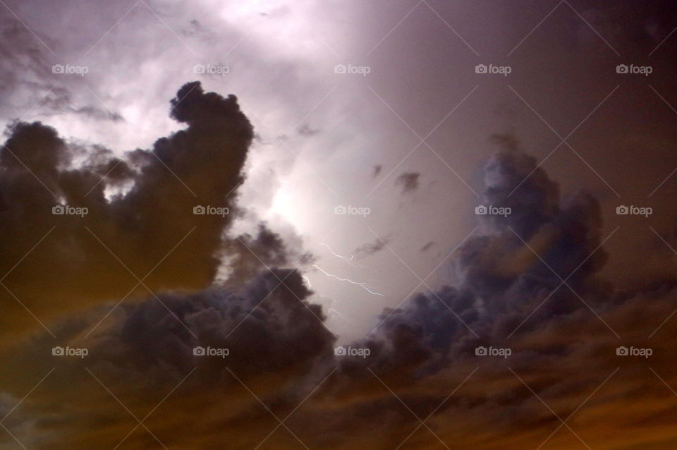 Low angle view of clouds and lightning