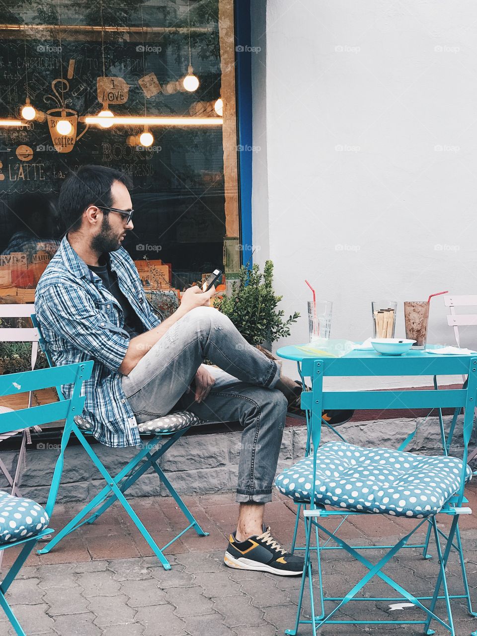 Bearded man using mobile in a street cafe 