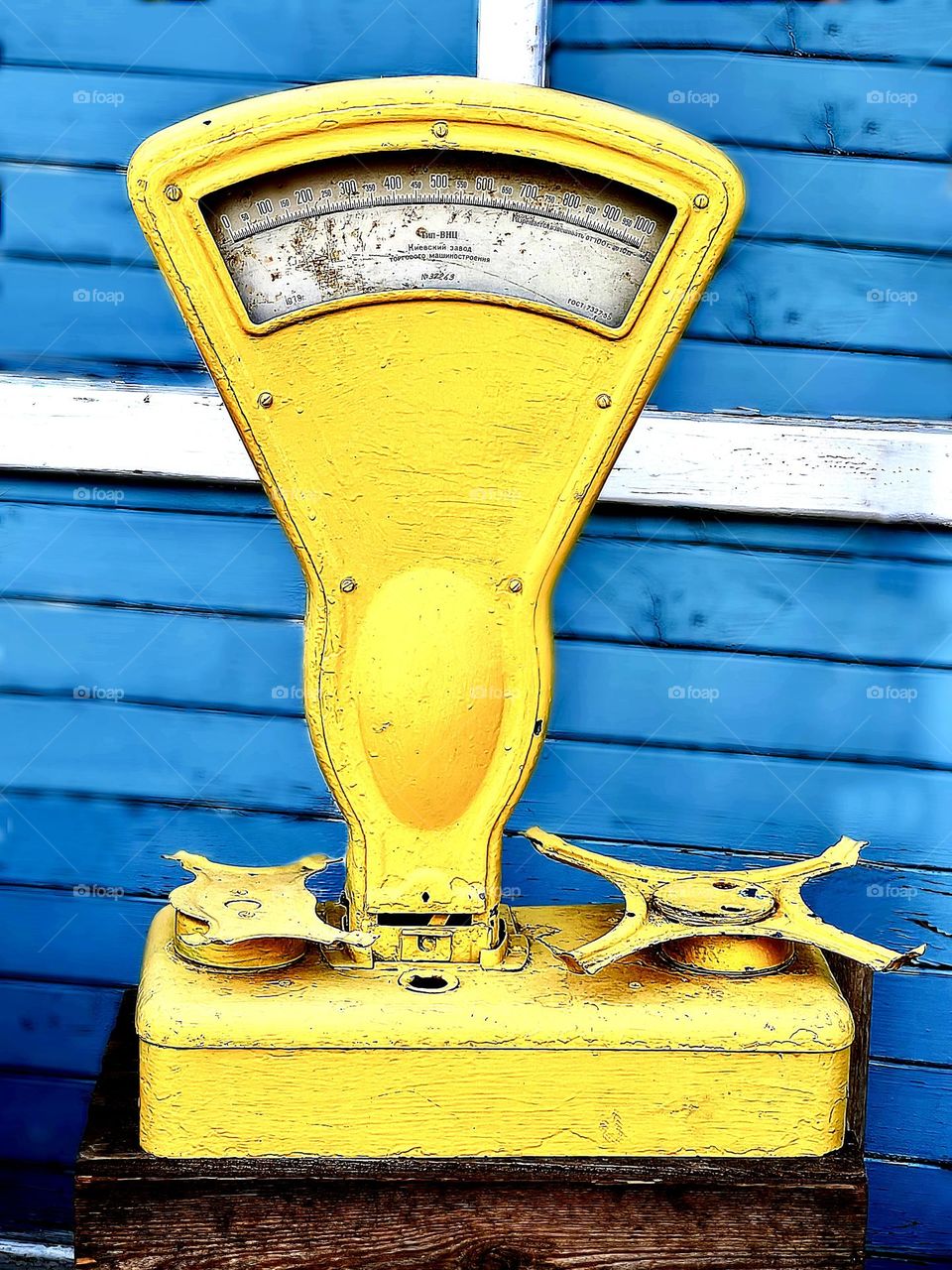 Yellow market scales on a blue wooden background
