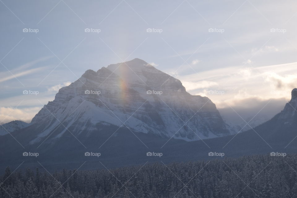Rainbow in front of snowcapped mountain