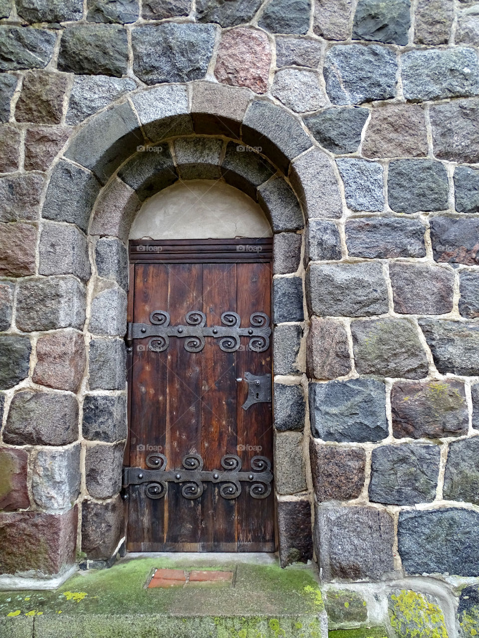 Old massive door in a wall of stones