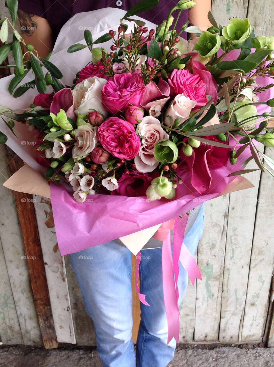 bright wedding bouquet of garden roses, green pistachio, lisianthus, hamelatsium in the florist's hands