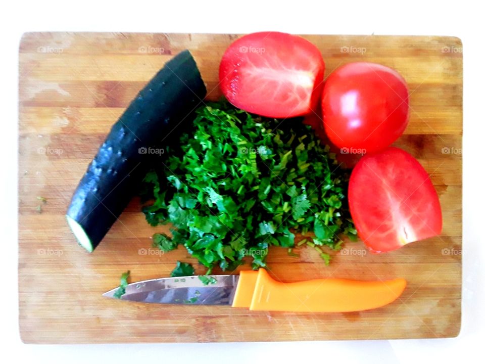 vegetables on a cutting board knife and chopped parsley