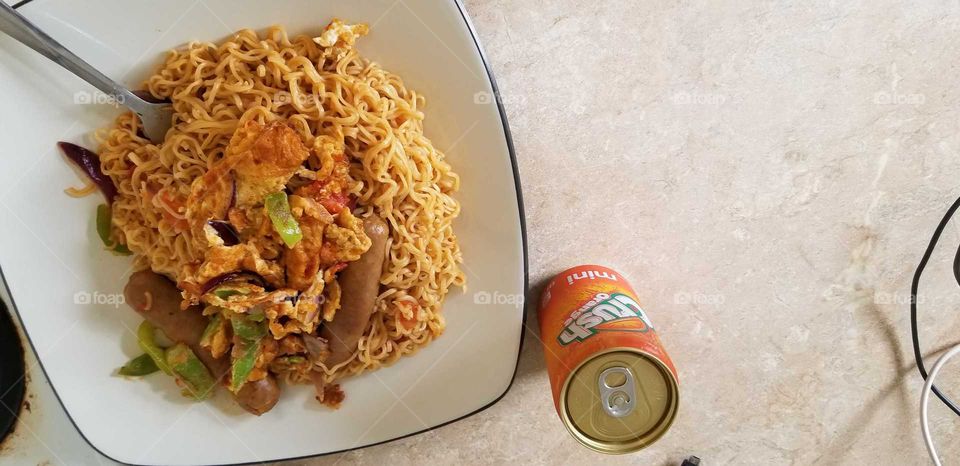 a can of cold crush with a robust plate of garnished noodles #Vegetables #eat #legumes #noodle #sausages #omelet #creative #culinary #kitchen #foodie #foodlover #foodphotographer #tasty #foodporn #eat #forkyea #mycooking #drink #hot #cold #homefood