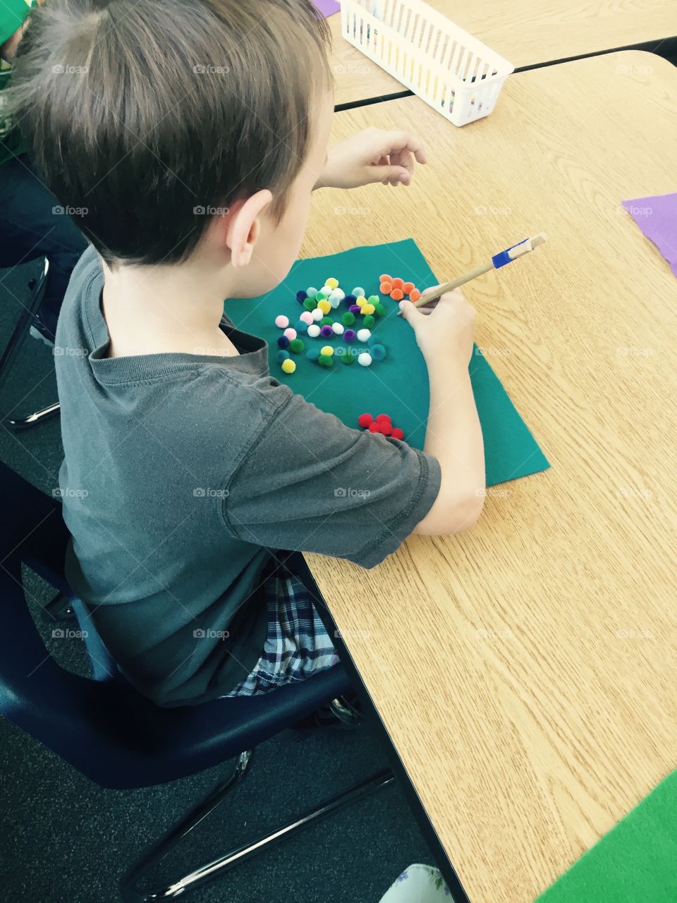 First Day of Kindergarten . Boy Sorting colors using chopsticks