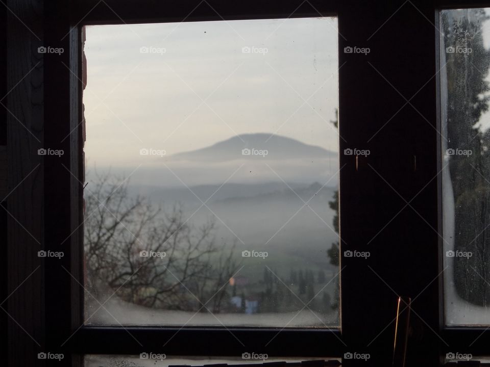 Watching outside of an old window on a cold day in Tuscany 