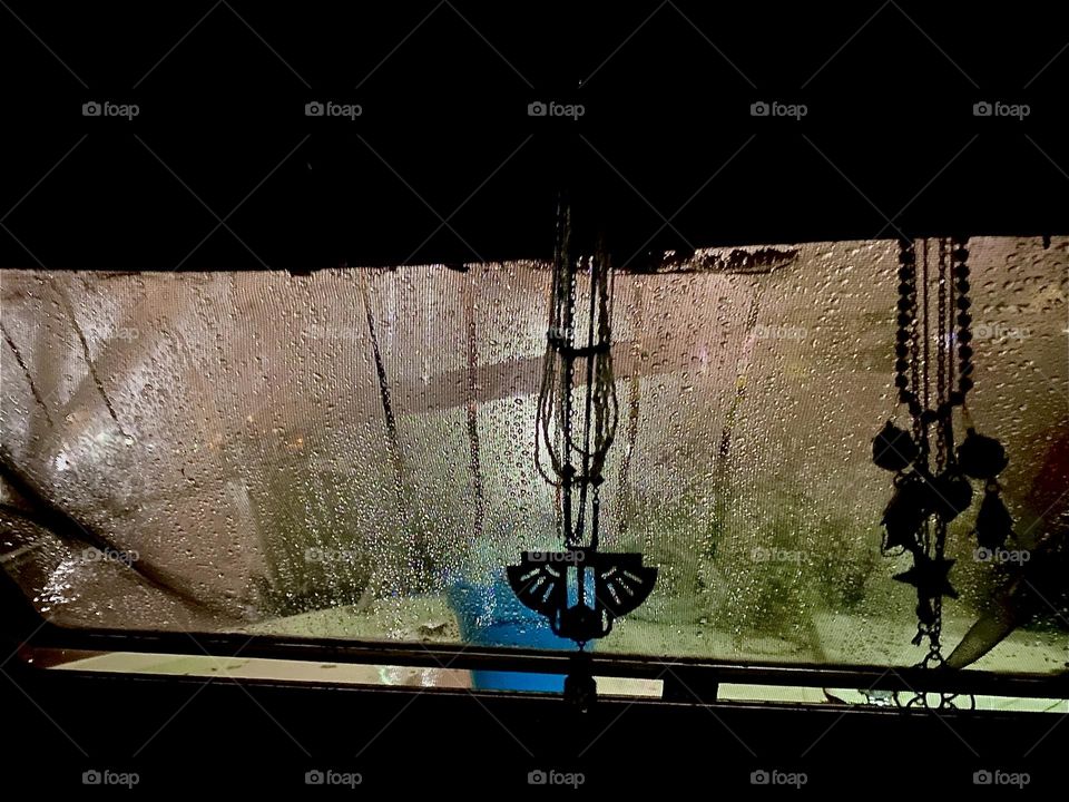 It is night aboard “Salvation”, our “28 ft 1969 Luhrs” at “Newtown Creek” in LIC, Queens. Lights outside cast shadows on the window and moisture from condensation and dripping rain create an appealing allure. 2023. Hypnotic Productions