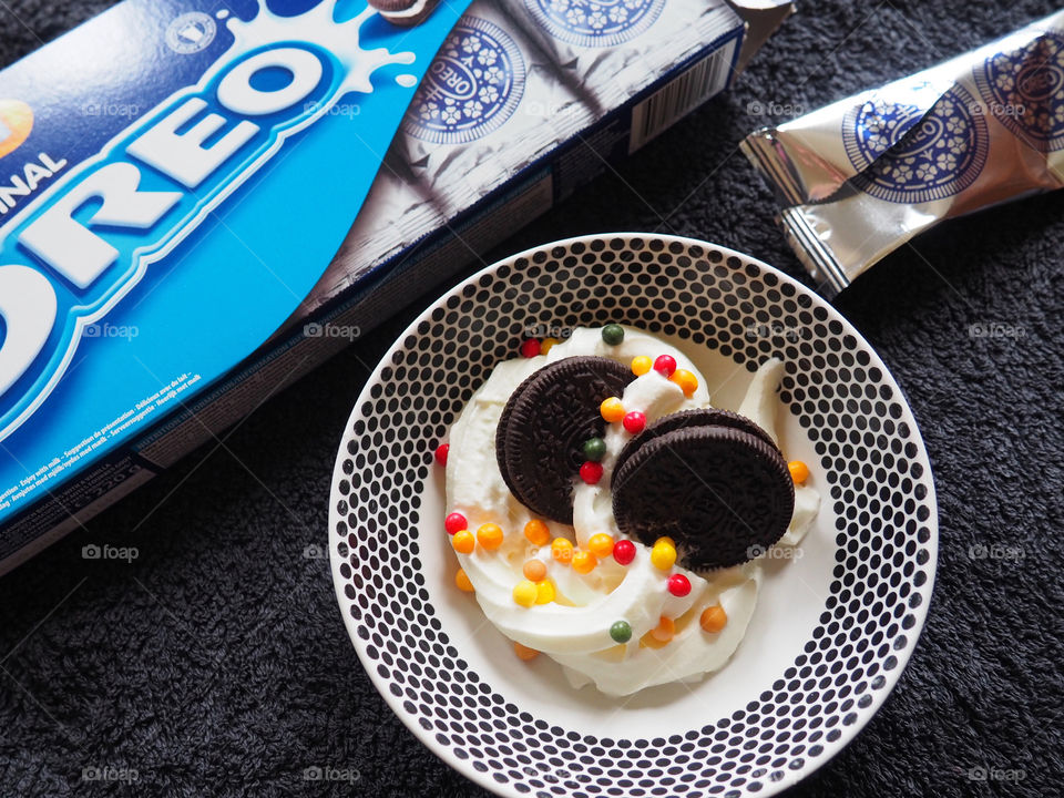 Oreo cookies with whipped cream and sprinkles.