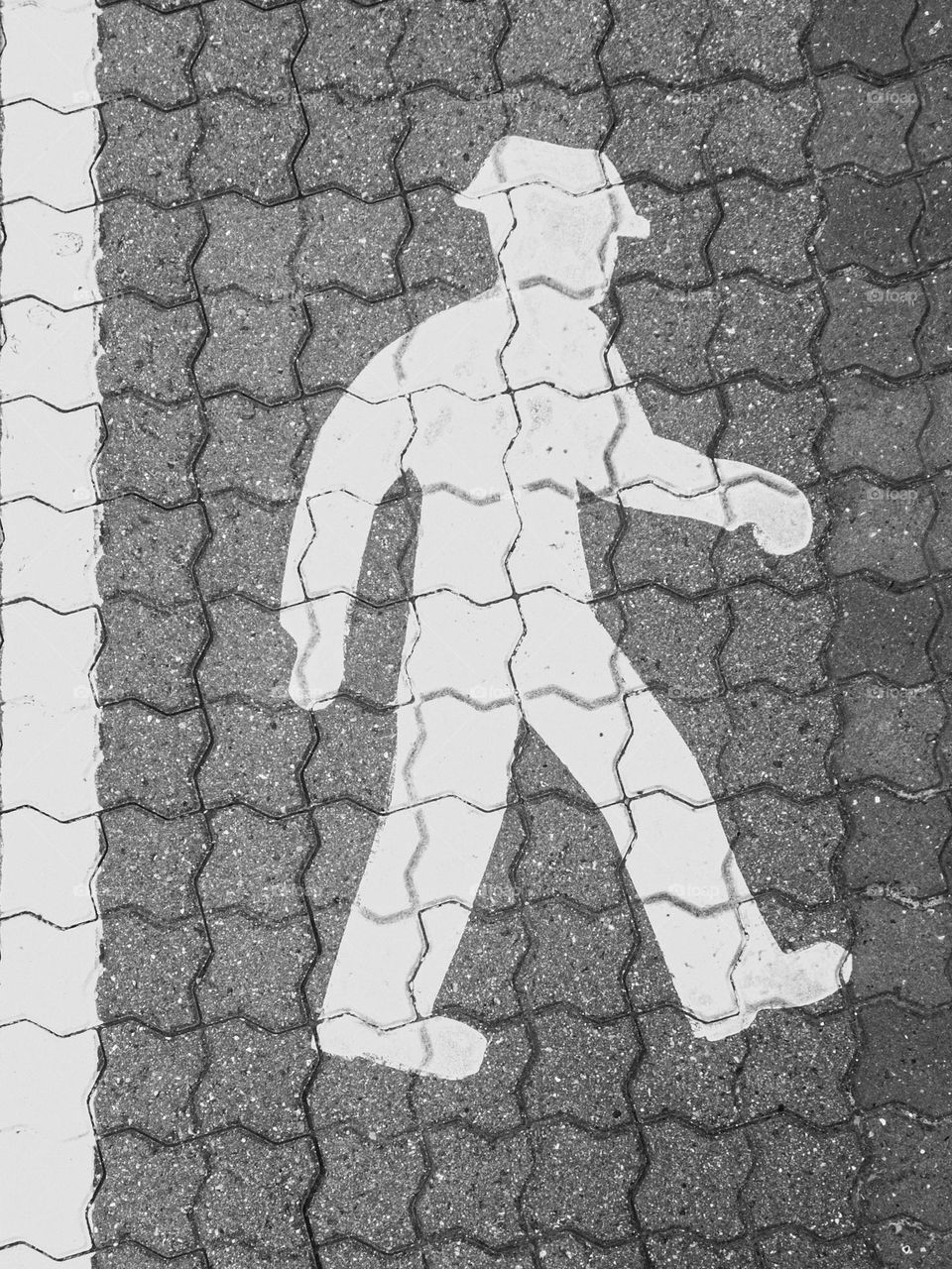 Painted walking man in hat on the side walk