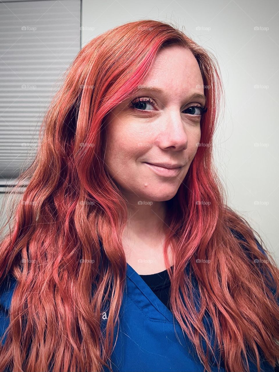 A woman with wavy multi colored red hair