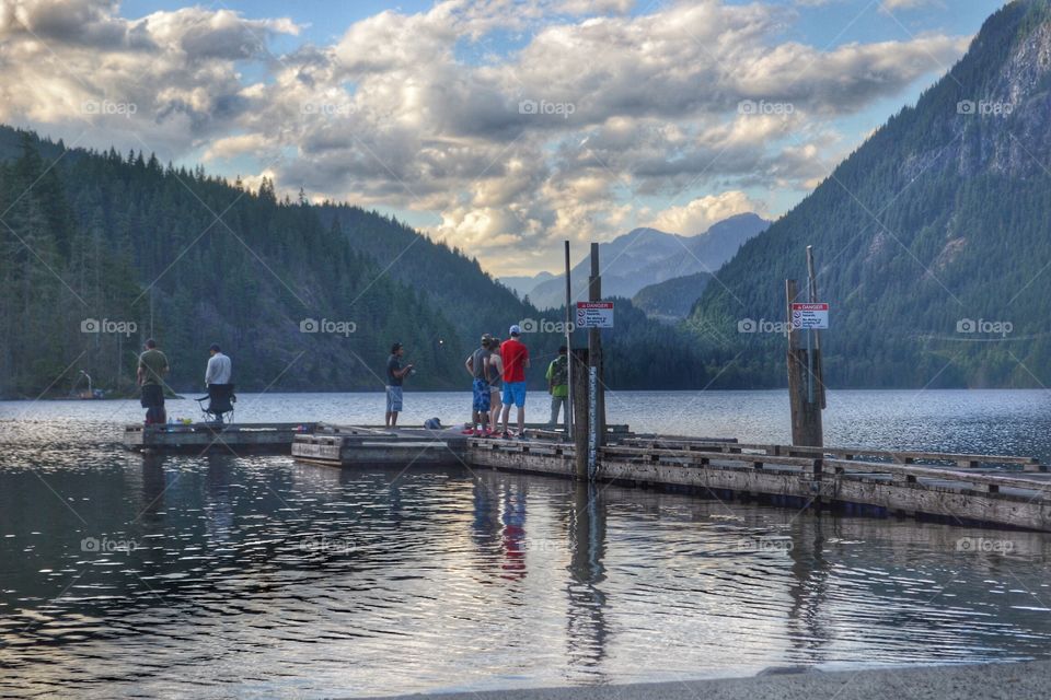 People Fishing off the dock. People Fishing off the dock of freshwater lake
