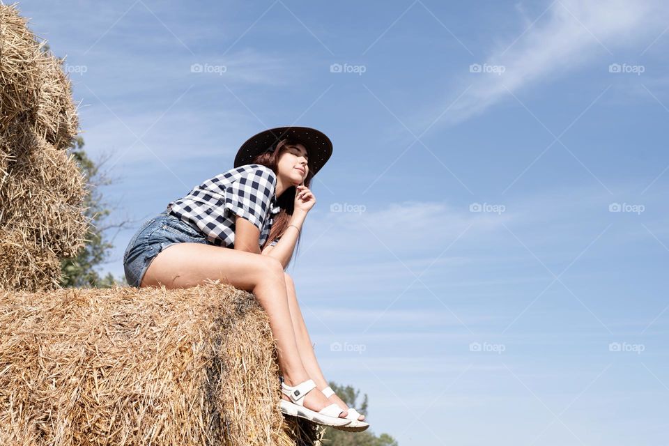 woman sitting on hay stack