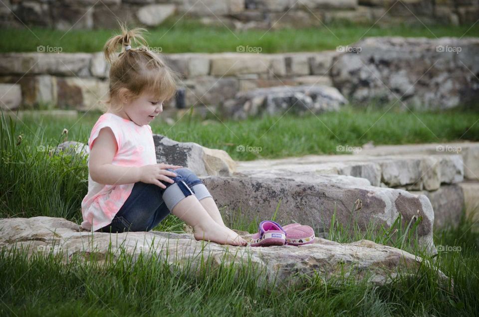 Cute girl sitting on rock