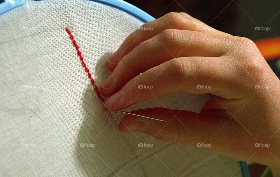 Woman doing embroidery work in indoors