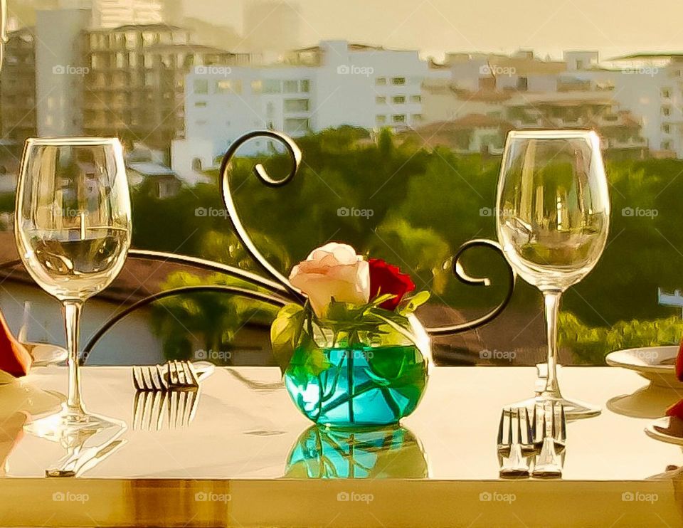 Inviting table setting with roses in a clear glass vase.