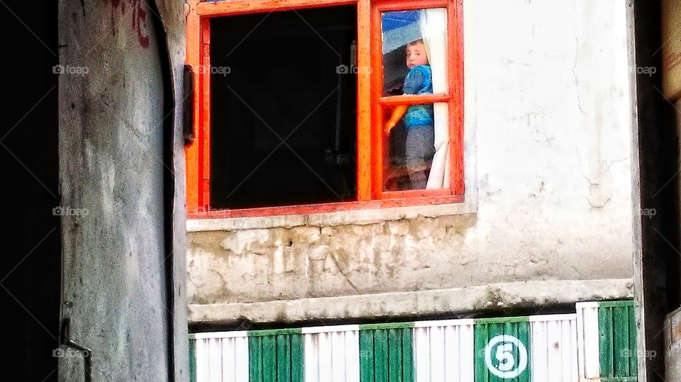 The funniest little boy ever,changing his position next to the window frame continuously, obviously being more interested in the outside street scenes then his homework.