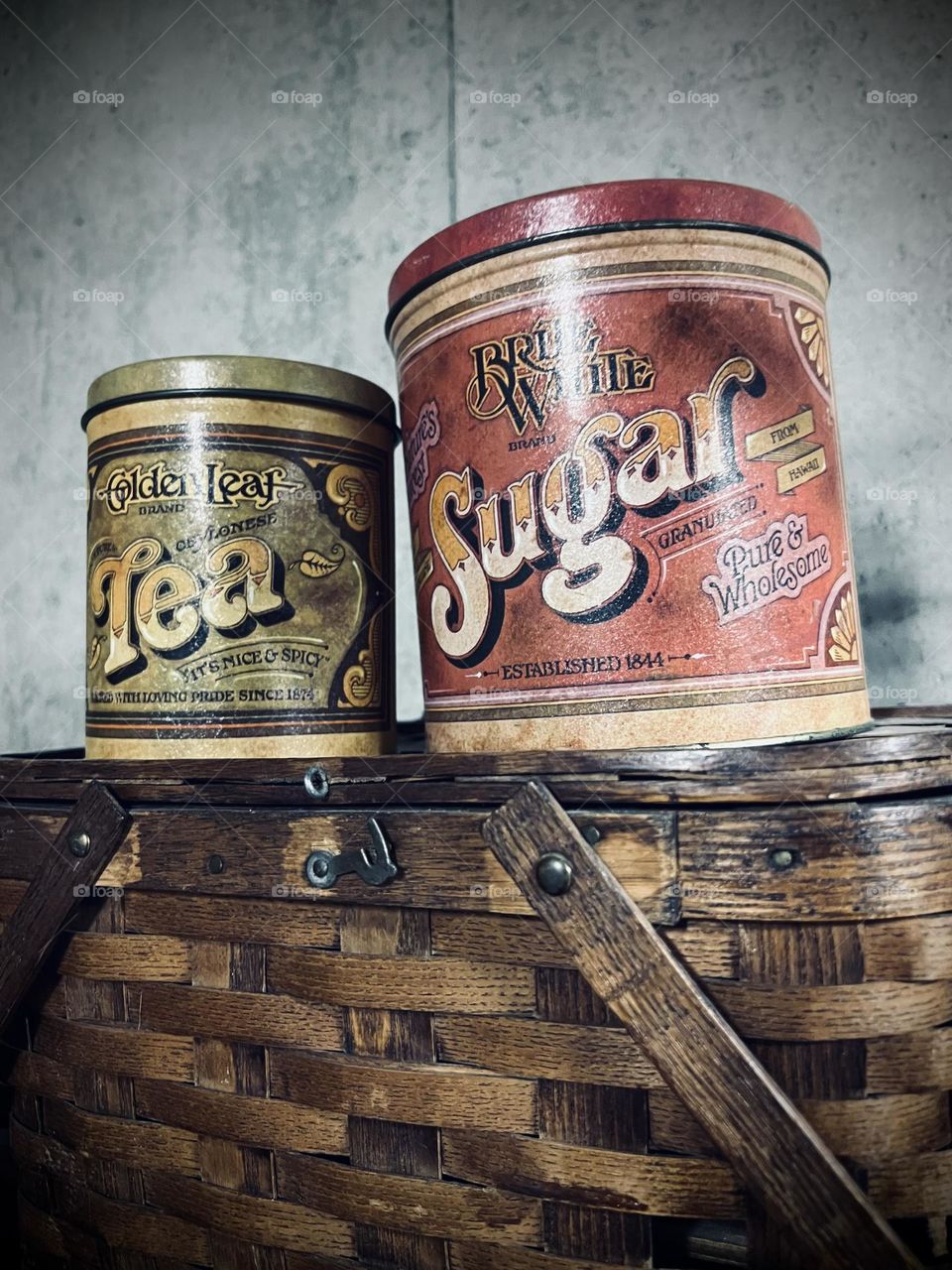 Antique tea and sugar containers on a picnic basket 
