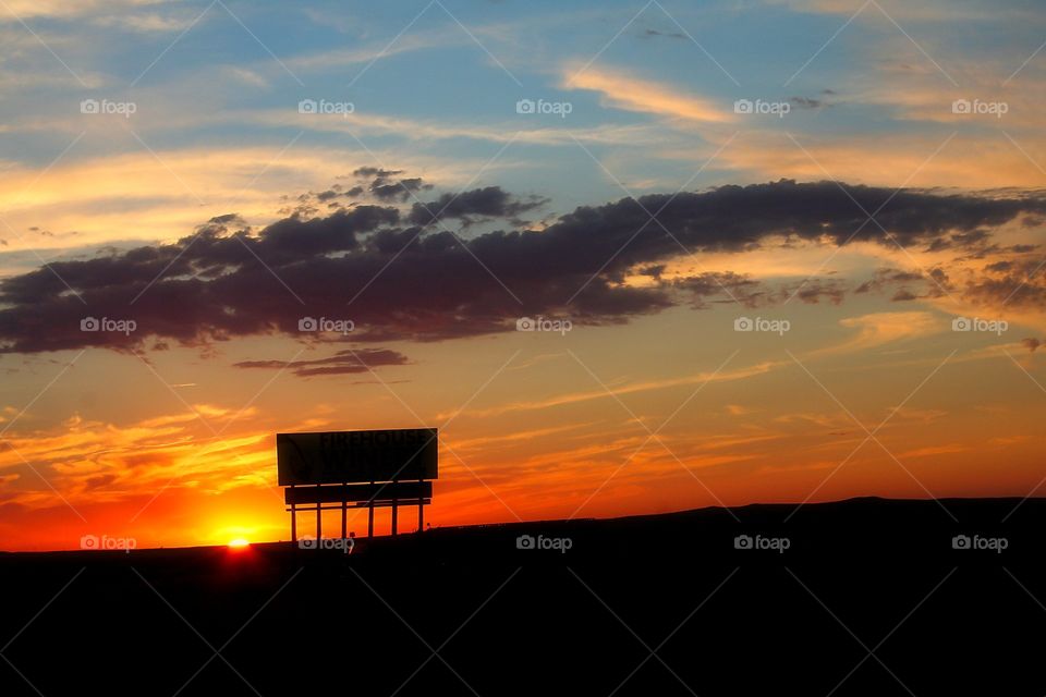 Signs of Sunset . Traveling past the end of the day and bidding the sun farewell, it puts on quite a spectacular show. Spreading across the horizon vibrant colors of Golds & Orange that will take your breath away.