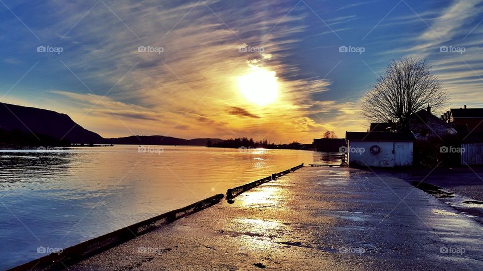 Sunset over mountain and lake near houses