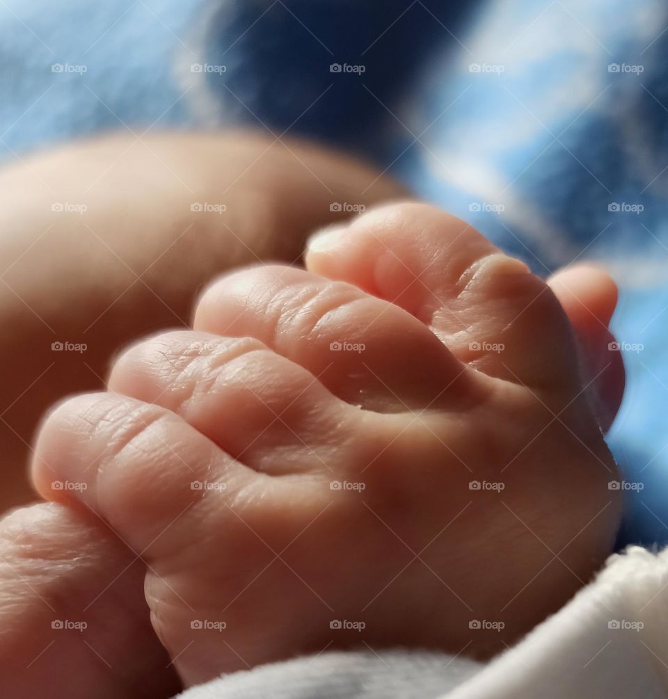 newborn holding mother's finger