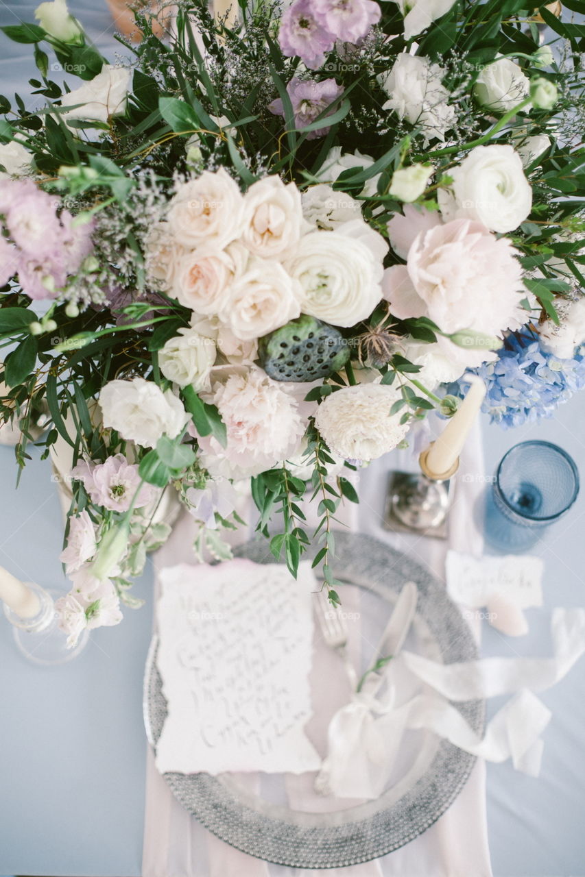 Graphic arts of beautiful wedding calligraphy cards and silver plate with cutlery on festive wedding table. 