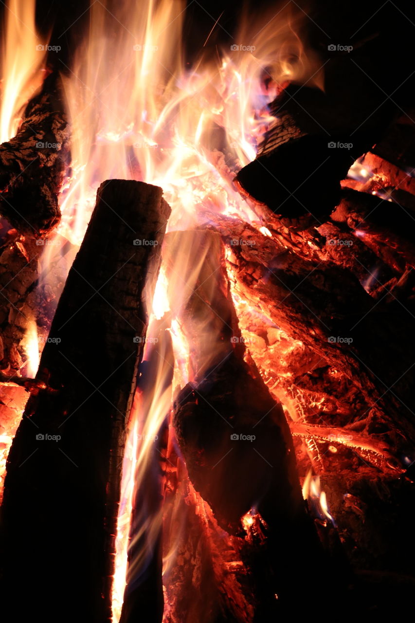 Burning logs, glowing coals, roaring fire. 