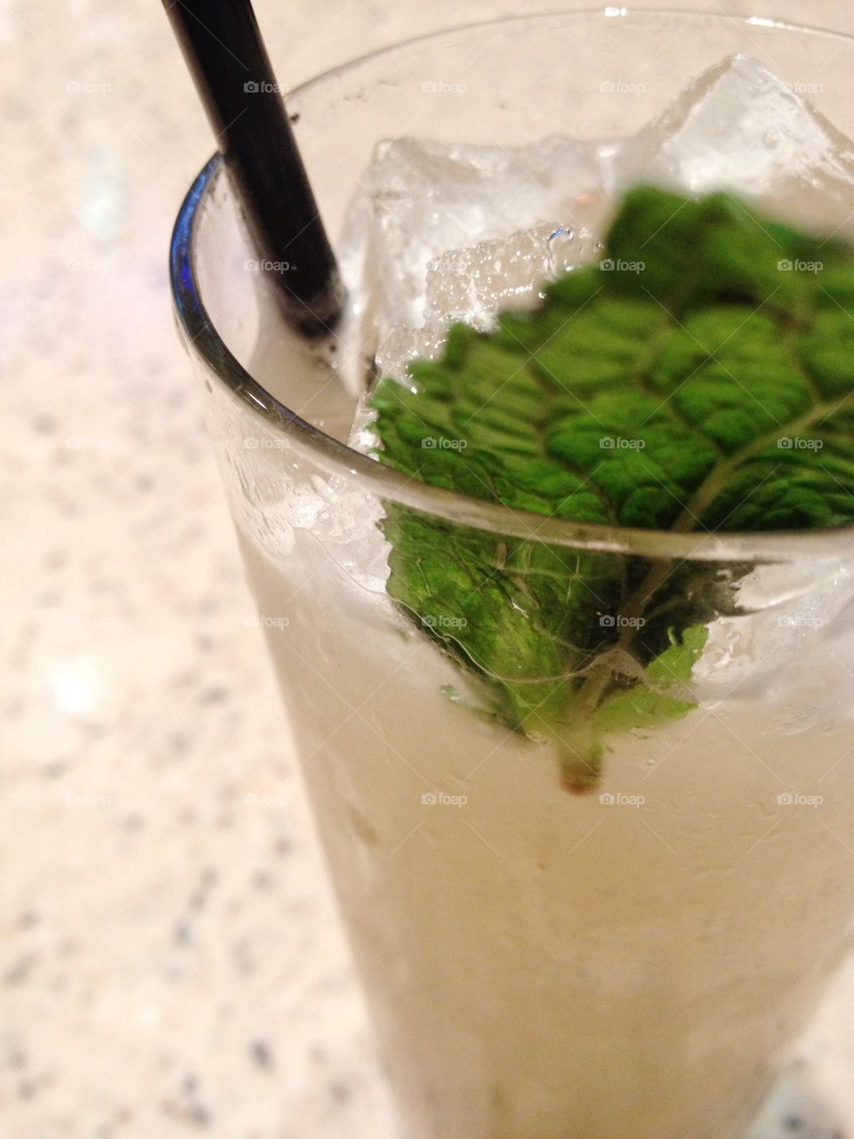 An alcoholic beverage with a fresh mint leaf