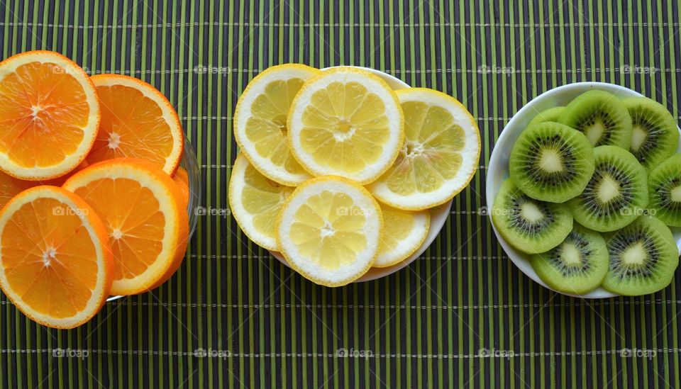 fresh sliced fruits top view green background