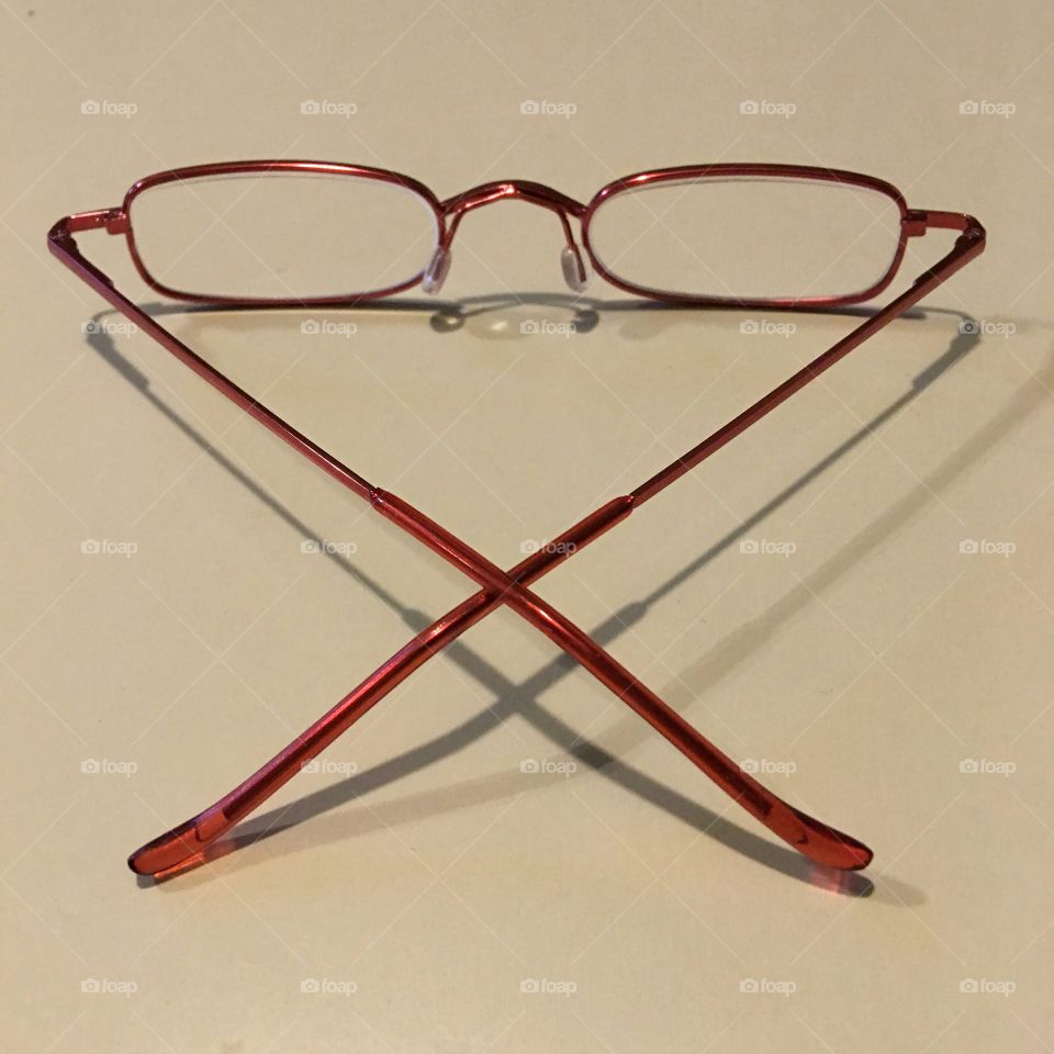 Thin red metal reading eyeglasses.