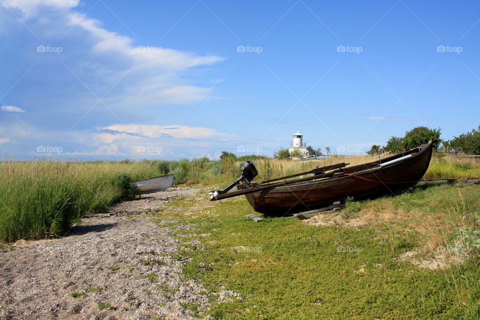 Boat on the beach with ligthouse
