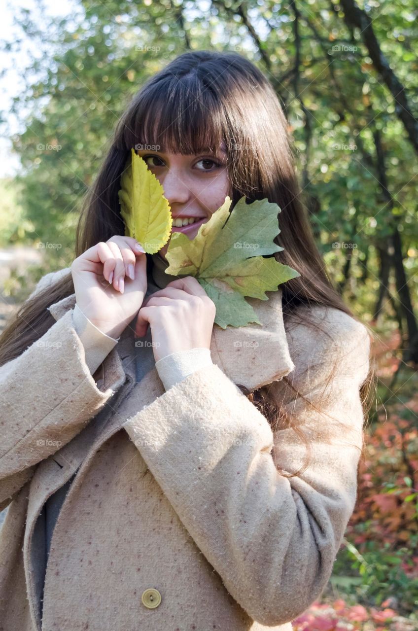 Smiling Young Girl on Autumn Background