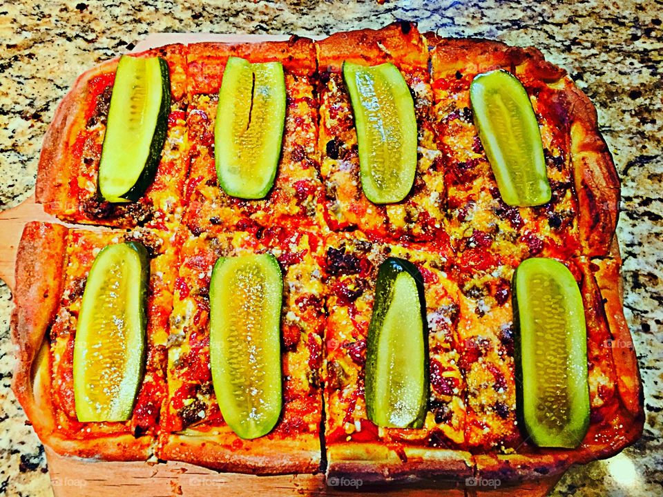 Bacon cheeseburger Pizza with pickle garnish 