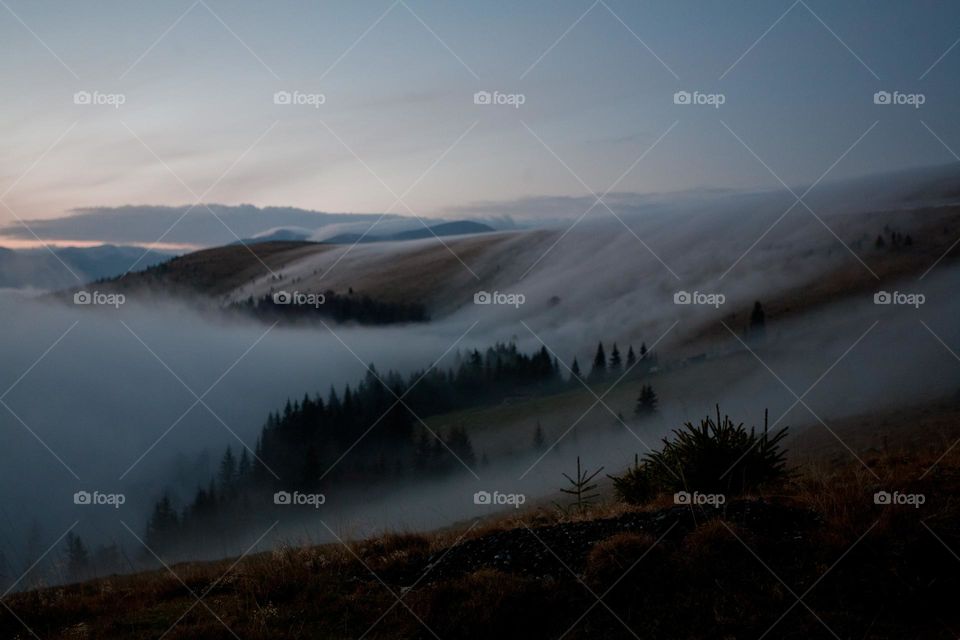 Mist flow over hills in moonlight 