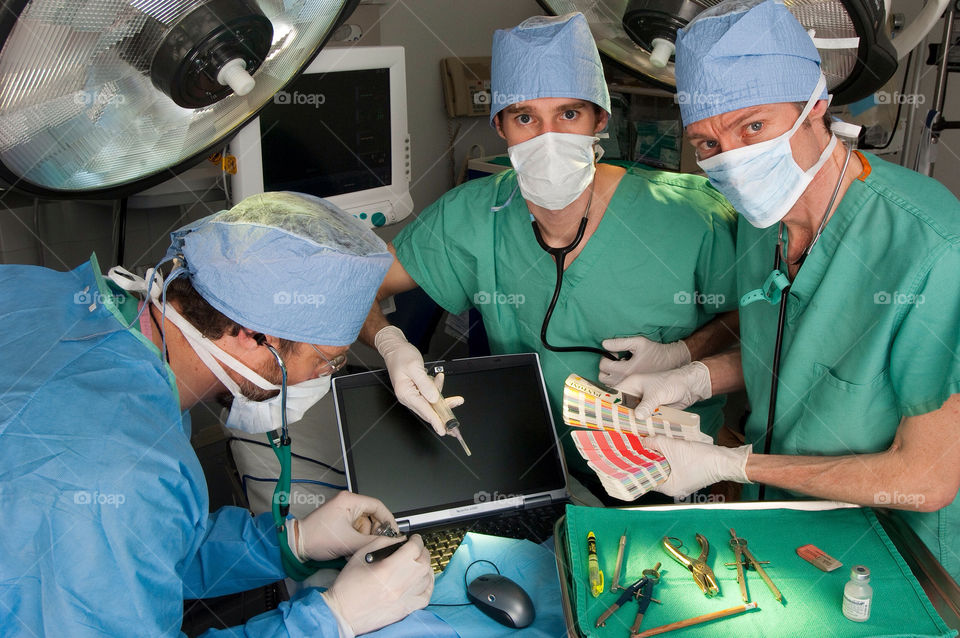 Three men operating on a computer and website in the emergency room