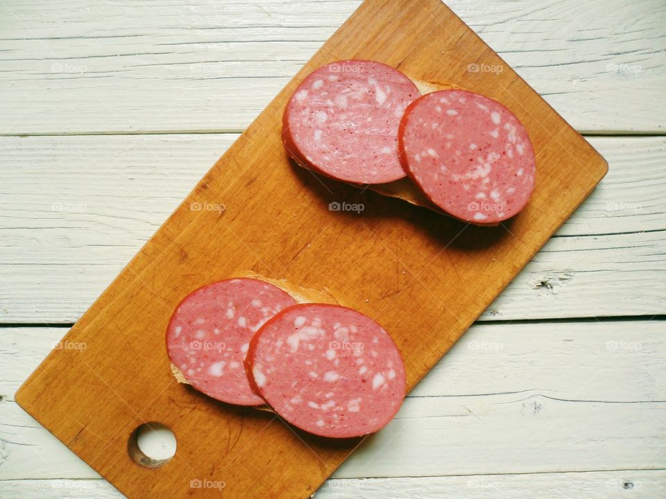 sandwiches with sausage on a cutting board