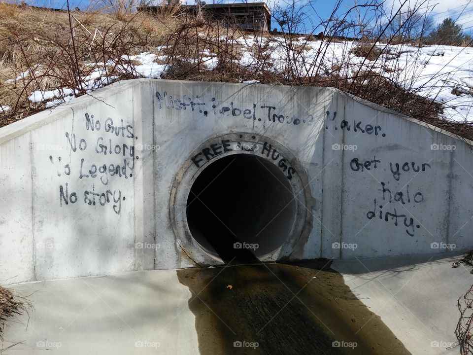 Playful graffiti scattered around a slippery drain pipe in winter [original photo].