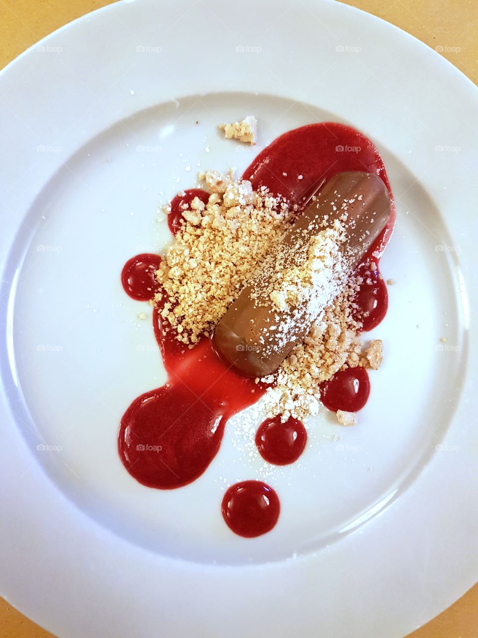Chocolate dessert with strawberry sauce and nougat grain