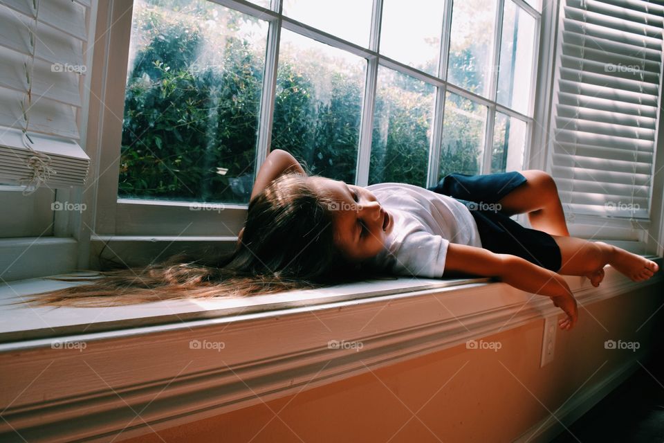Little girl sleeping on windowsill