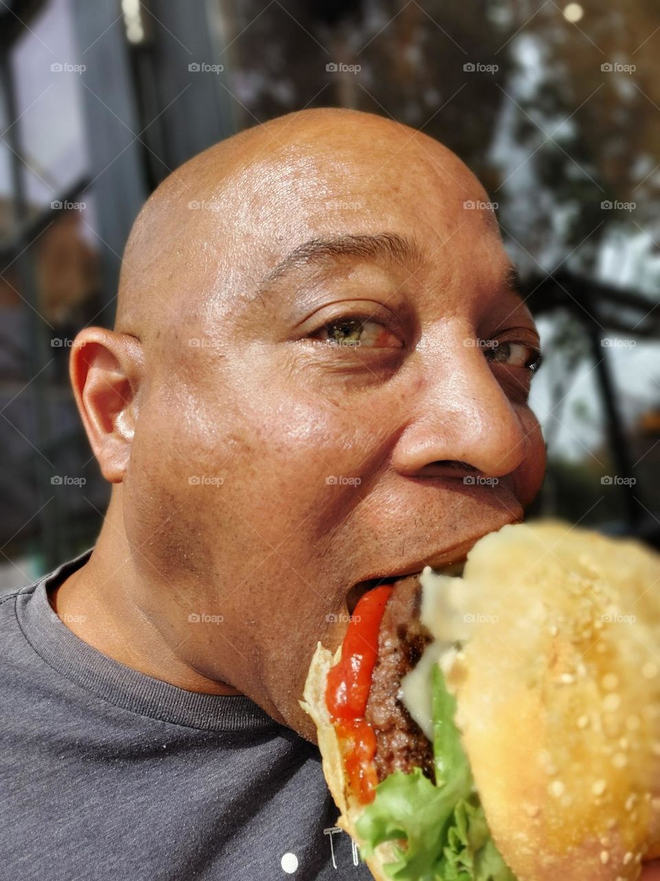 Taking a bite of a delicious avocado bacon Burger in the downtown district of Sacramento California
