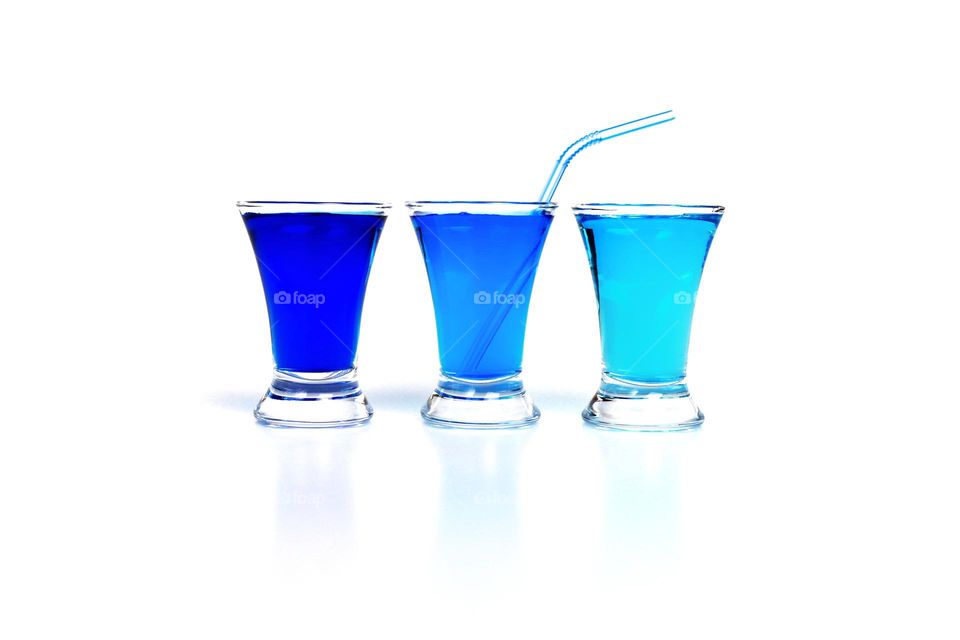 three glasses with blue liquid