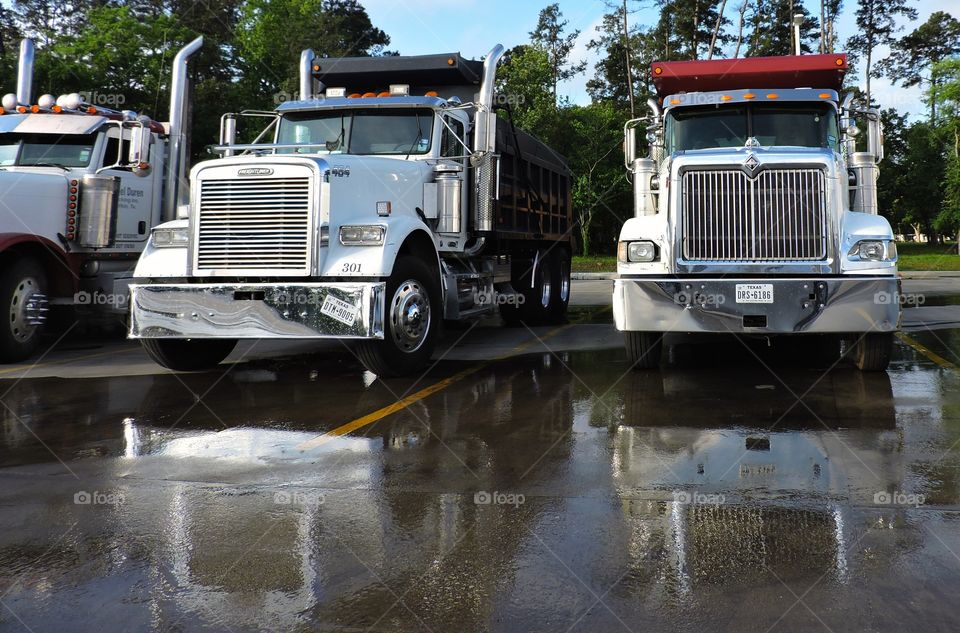 Trucks have reflections. Reflections of trucks after a rain