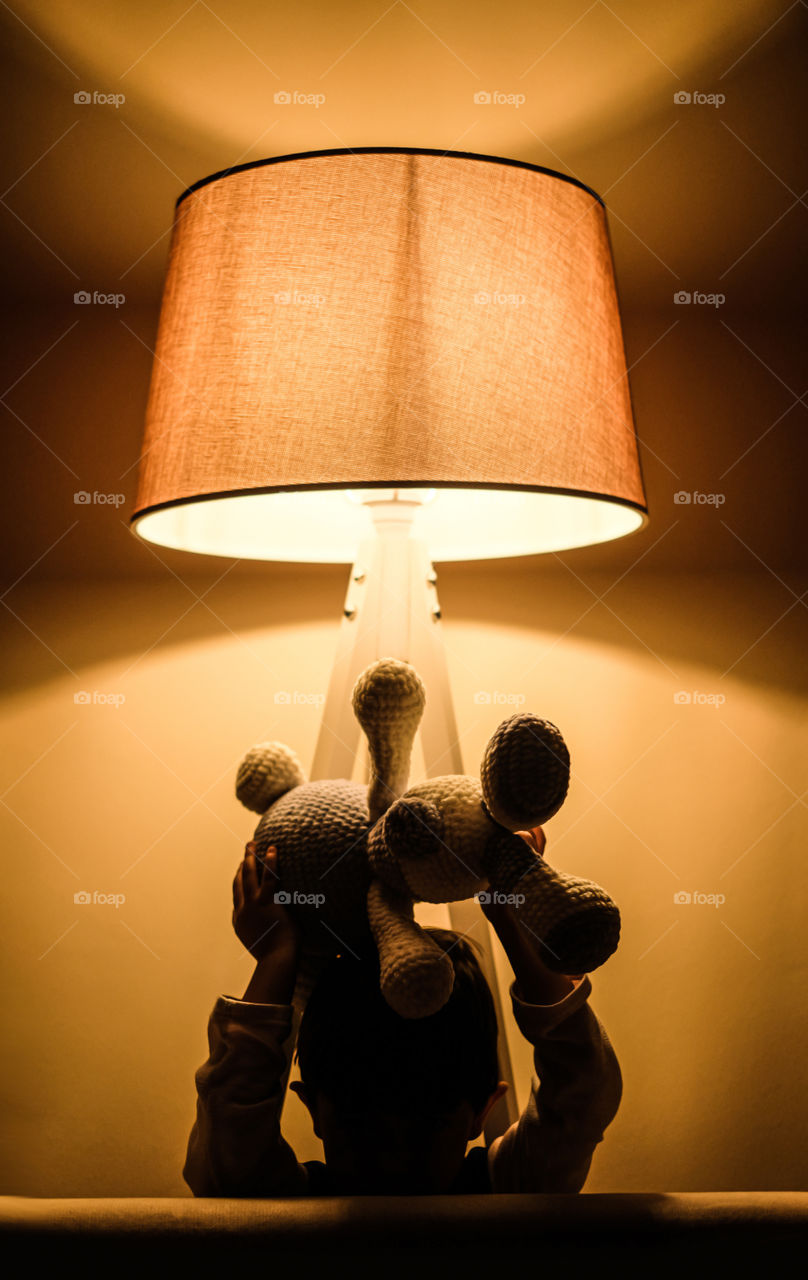 Child playing under the lamp