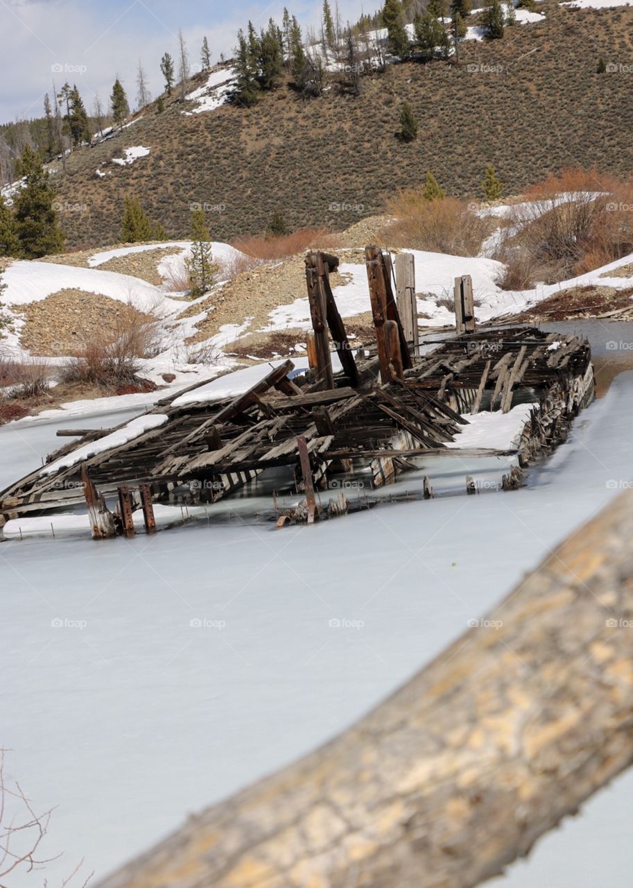 An abandoned gold mining dredge, frozen in a mountain lake in Colorado. 